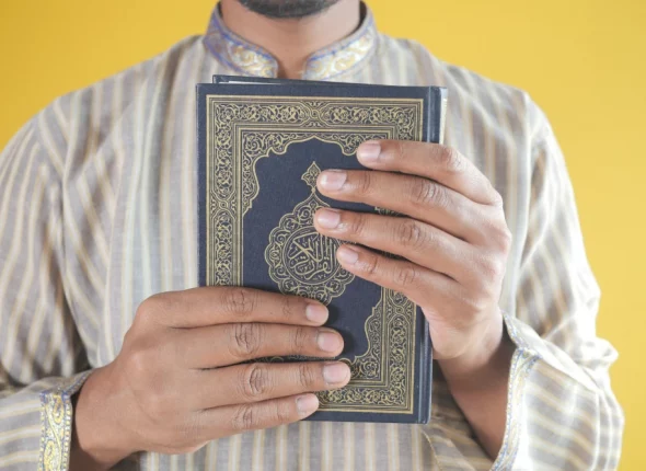 muslim-man-hand-holding-holy-book-quran-with-copy-2023-11-27-05-20-08-utc
